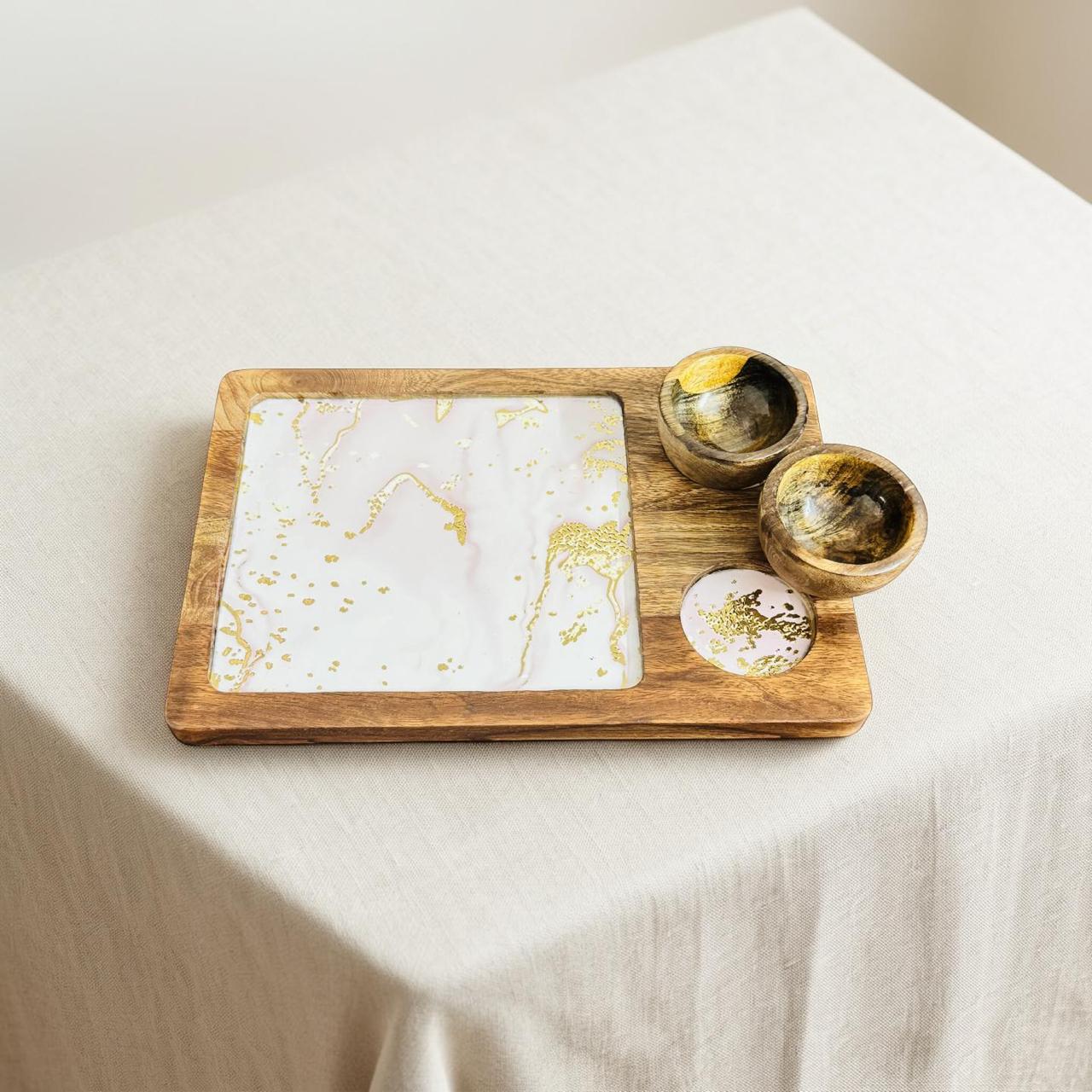 Wooden tray with marbleized coasters and bowls on a white surface
