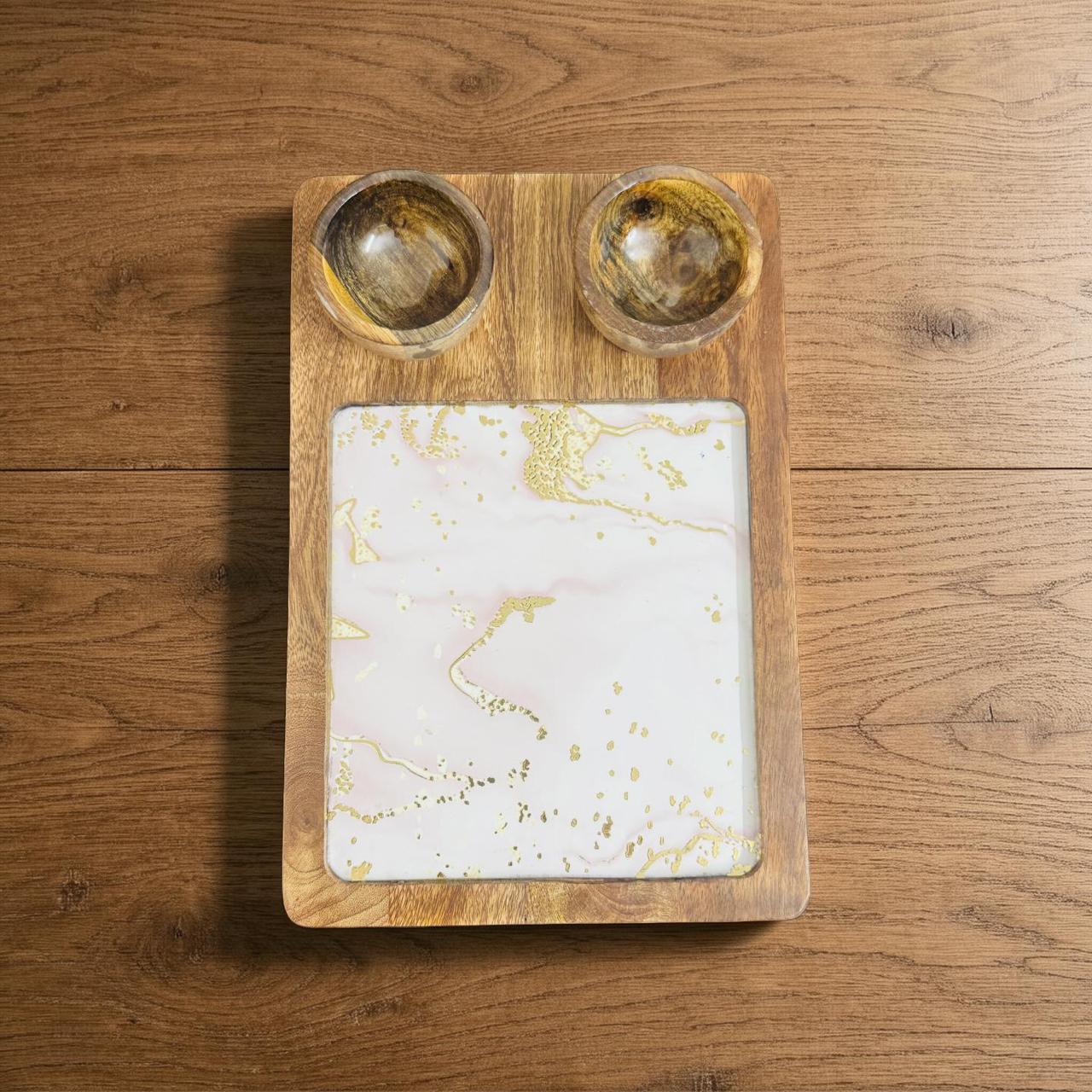 Wooden tray with marbleized center and two small round containers on a wooden surface