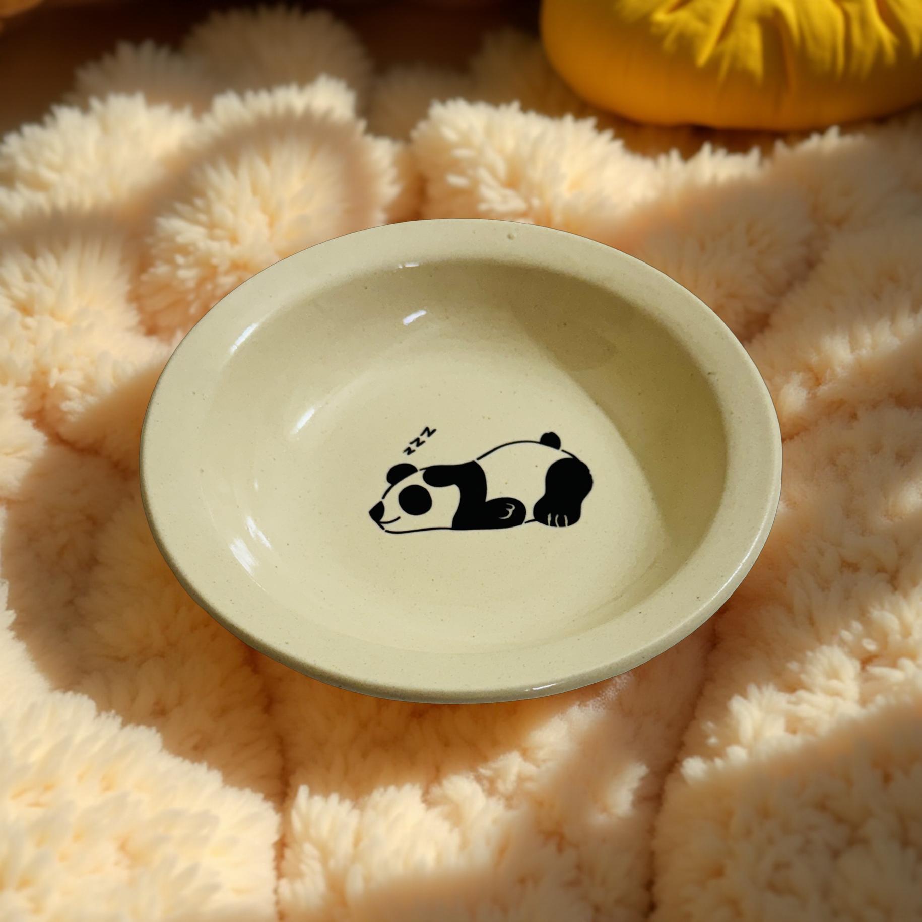 Beige ceramic dish with a panda design on a fluffy pink surface