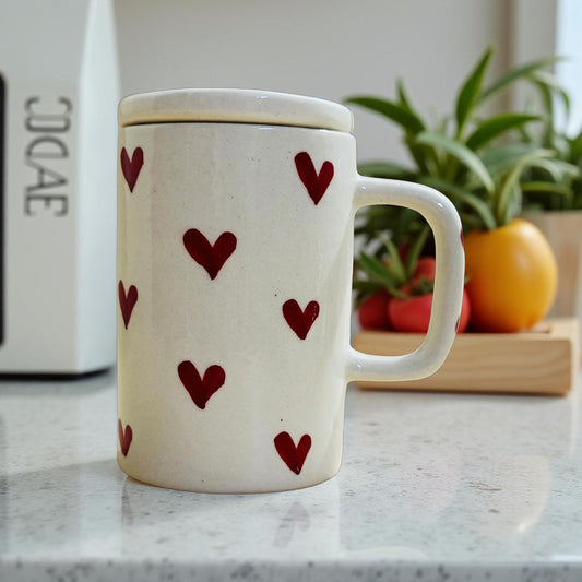 White mug with red heart patterns on a kitchen counter