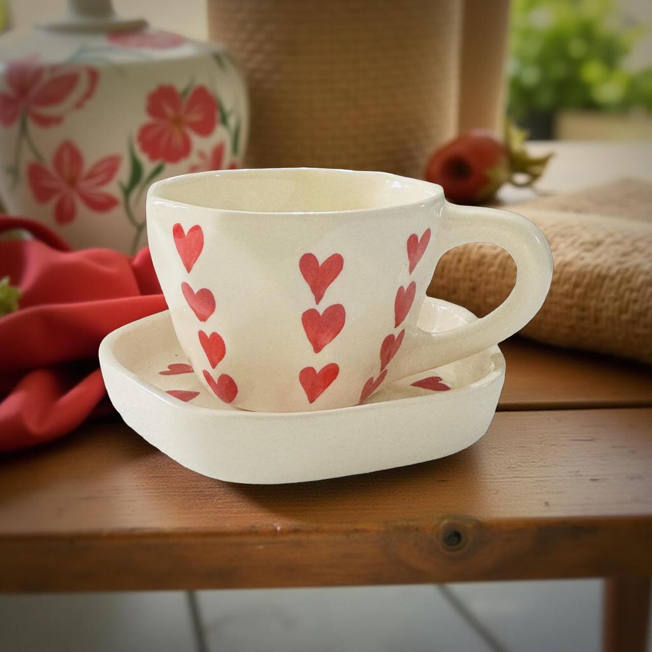 Ceramic cup with red heart patterns on a wooden surface