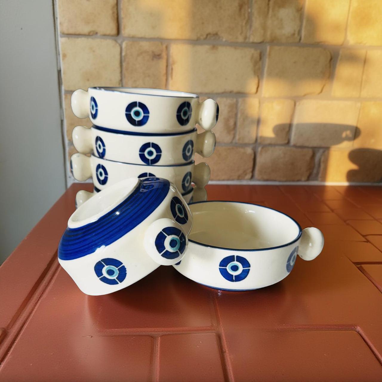 Set of ceramic bowls with blue patterns on a tiled surface