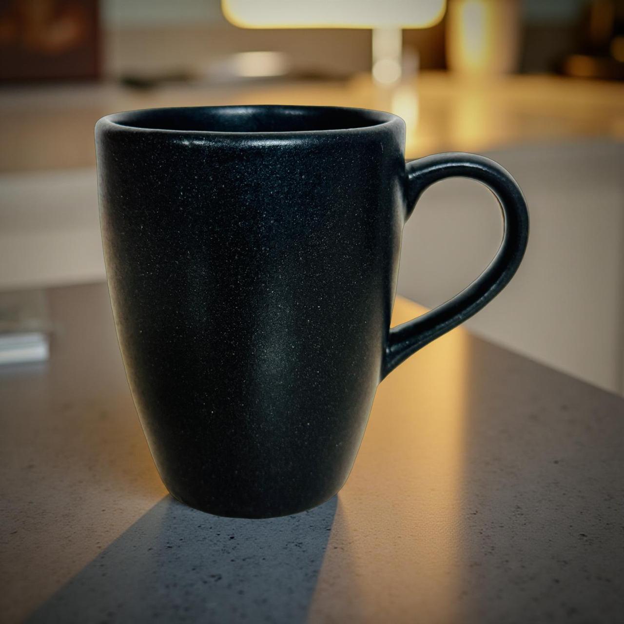 Black mug on a kitchen counter with a blurred background