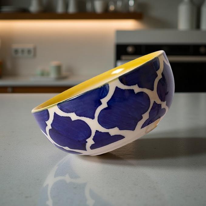 Blue and white patterned bowl with yellow interior on a kitchen counter