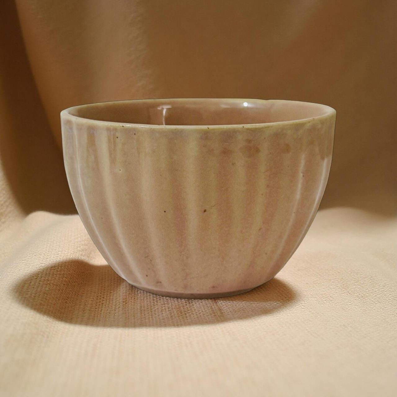 Pink ceramic cup on a beige fabric background