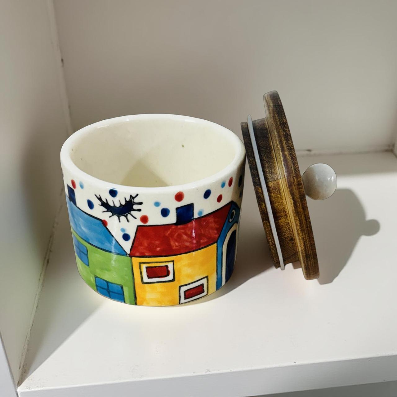 Colorful ceramic jar with a lid on a white surface