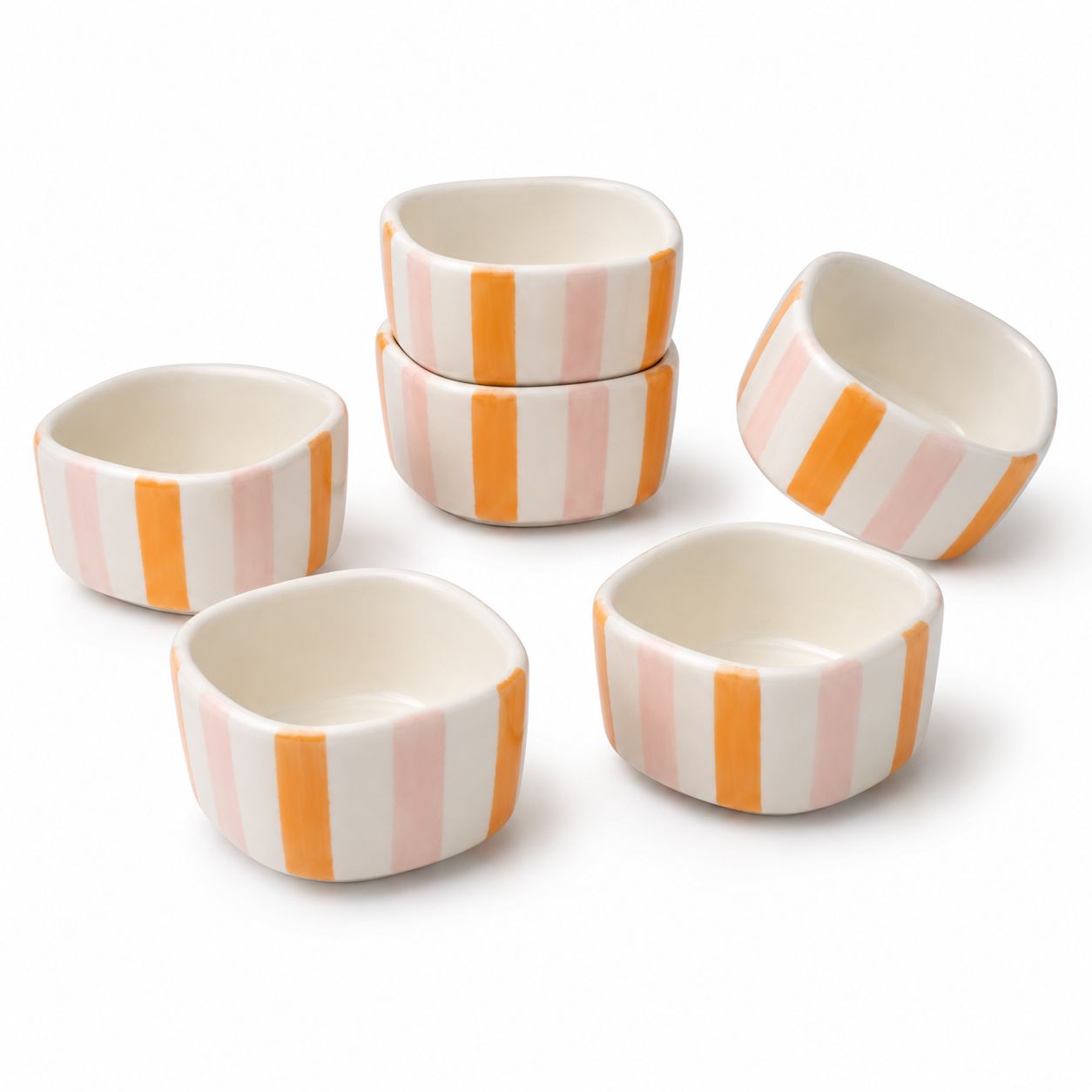 Set of six small ceramic bowls with orange and pink striped patterns on a white background