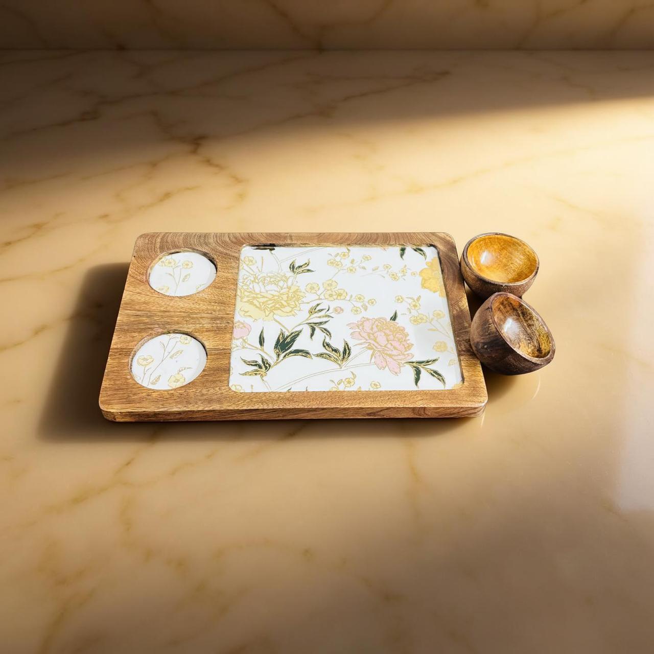 Wooden tray with floral placemat, coasters, and small bowls on a marble surface