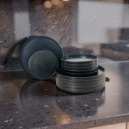 Set of dark gray ceramic plates on a speckled countertop