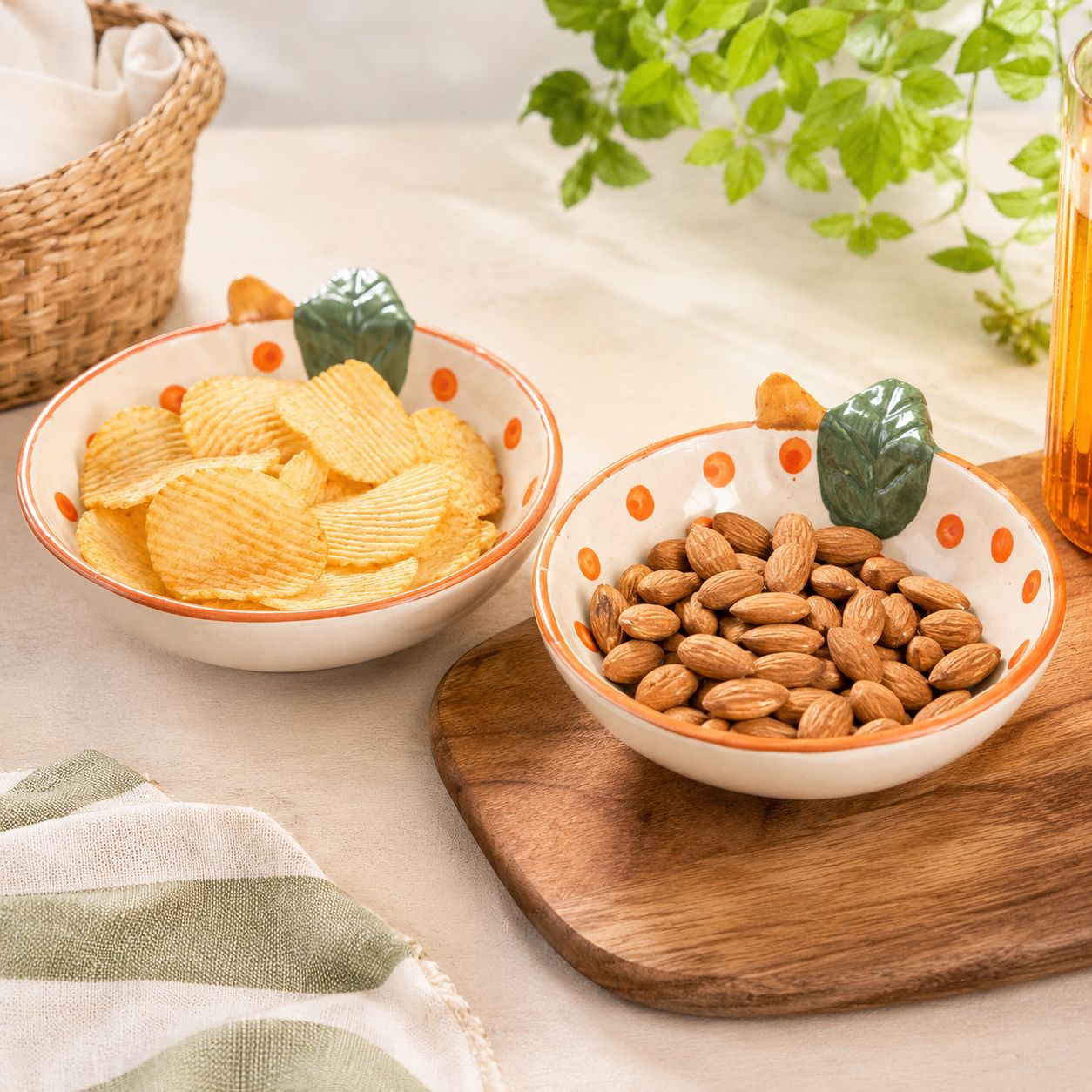 Two bowls of snacks on a wooden board with a plant in the background
