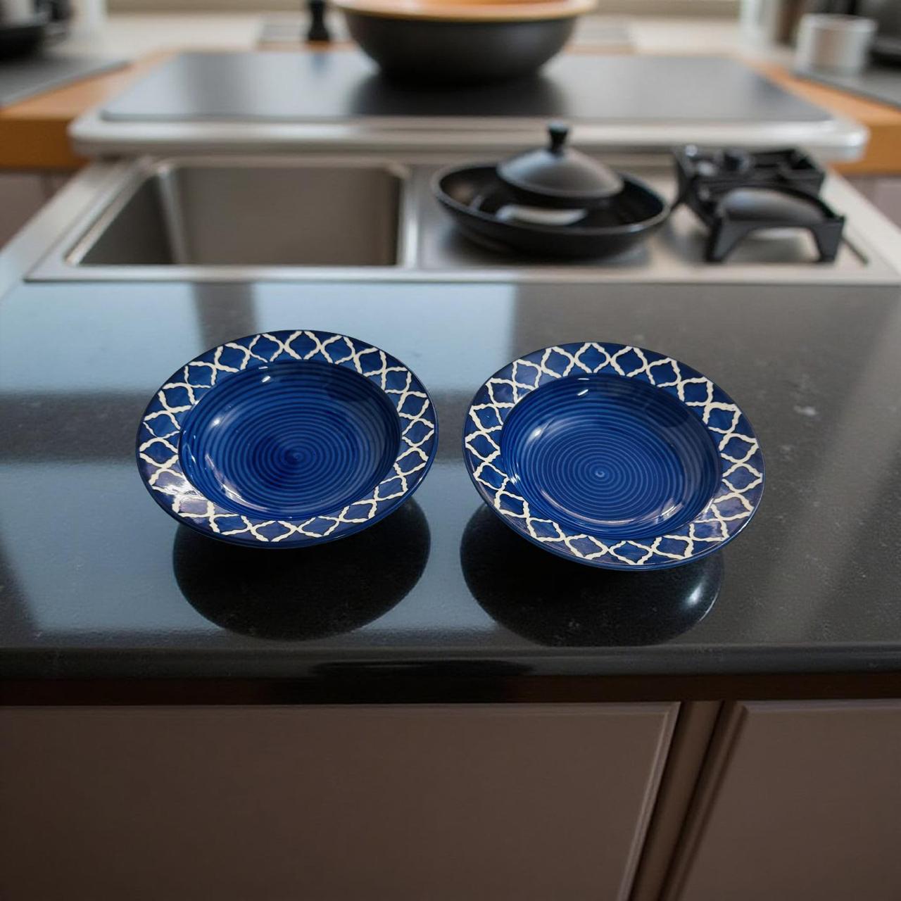 Two blue ceramic dishes with white patterns on a kitchen counter.