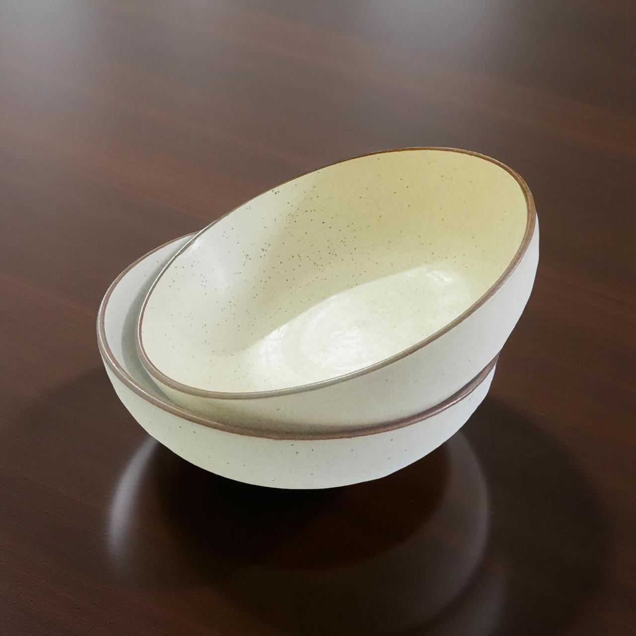 White ceramic bowl with brown rim on a dark wooden surface