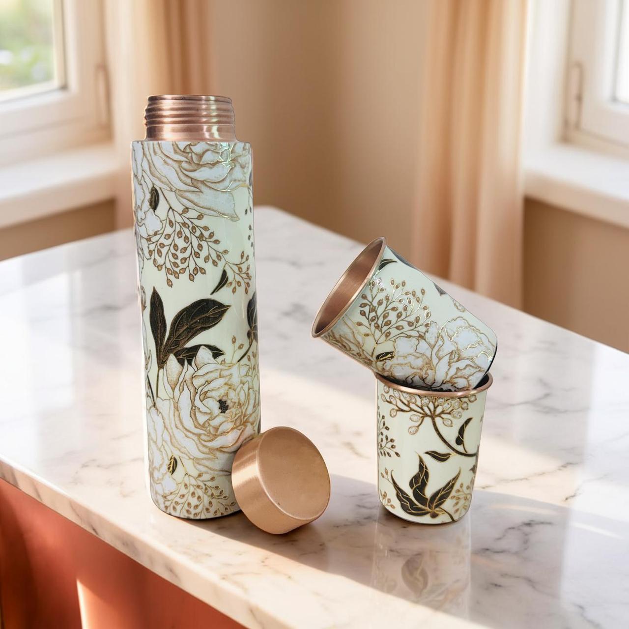 Floral-patterned tumbler and cups on a marble surface with a window in the background