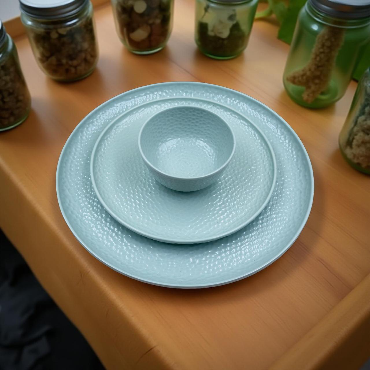 Light blue ceramic plate and bowl set on a wooden surface with jars of seeds in the background.