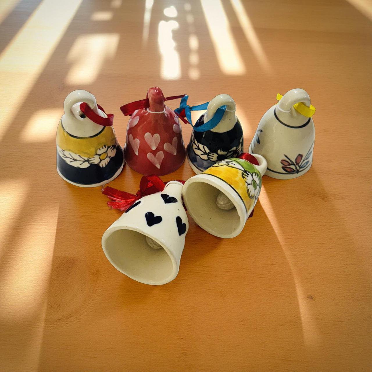 Set of colorful ceramic bells on a wooden surface