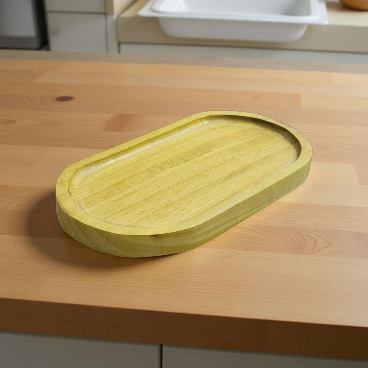 Light wooden oval serving tray placed on a kitchen counter in natural light