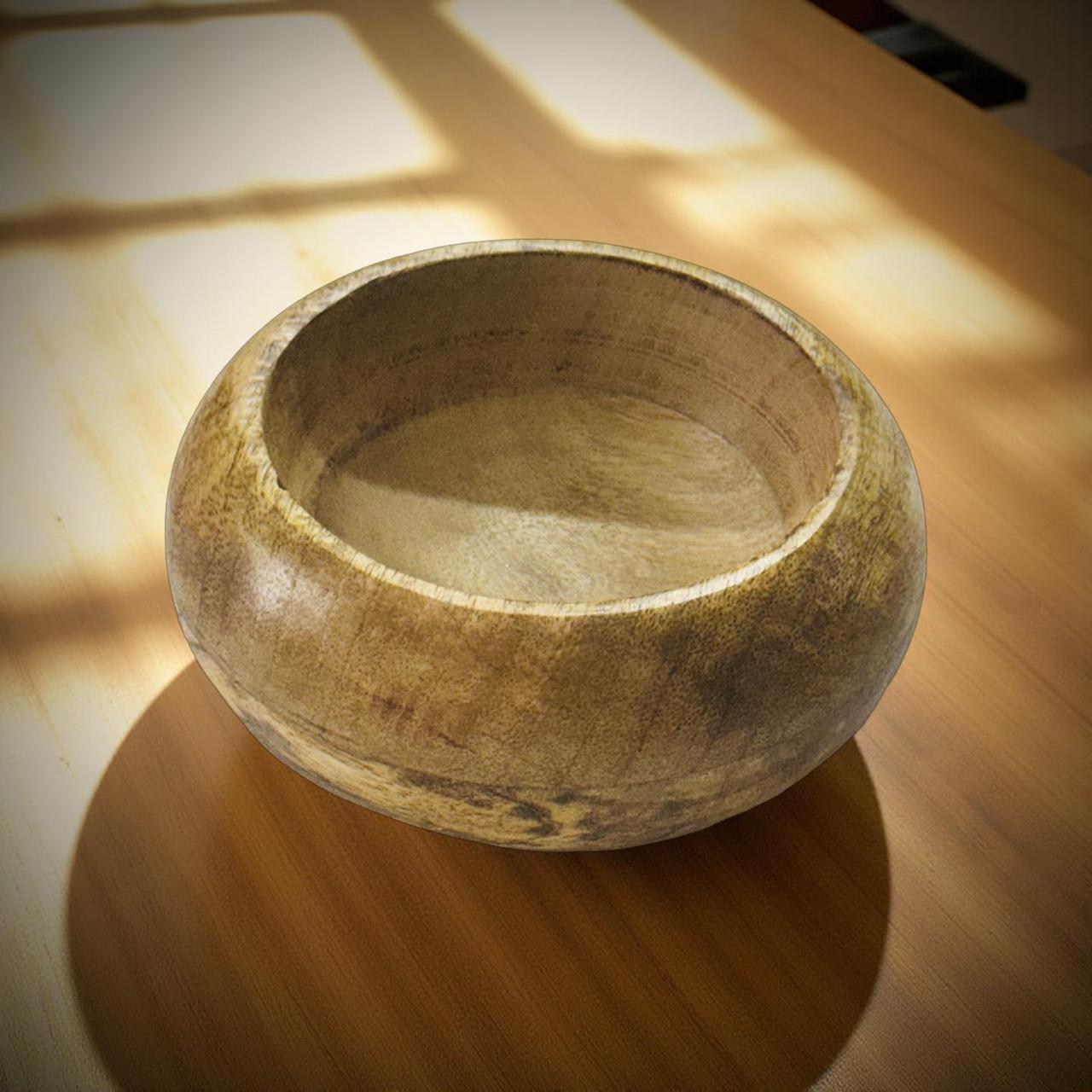 Wooden bowl on a wooden surface with sunlight casting shadows
