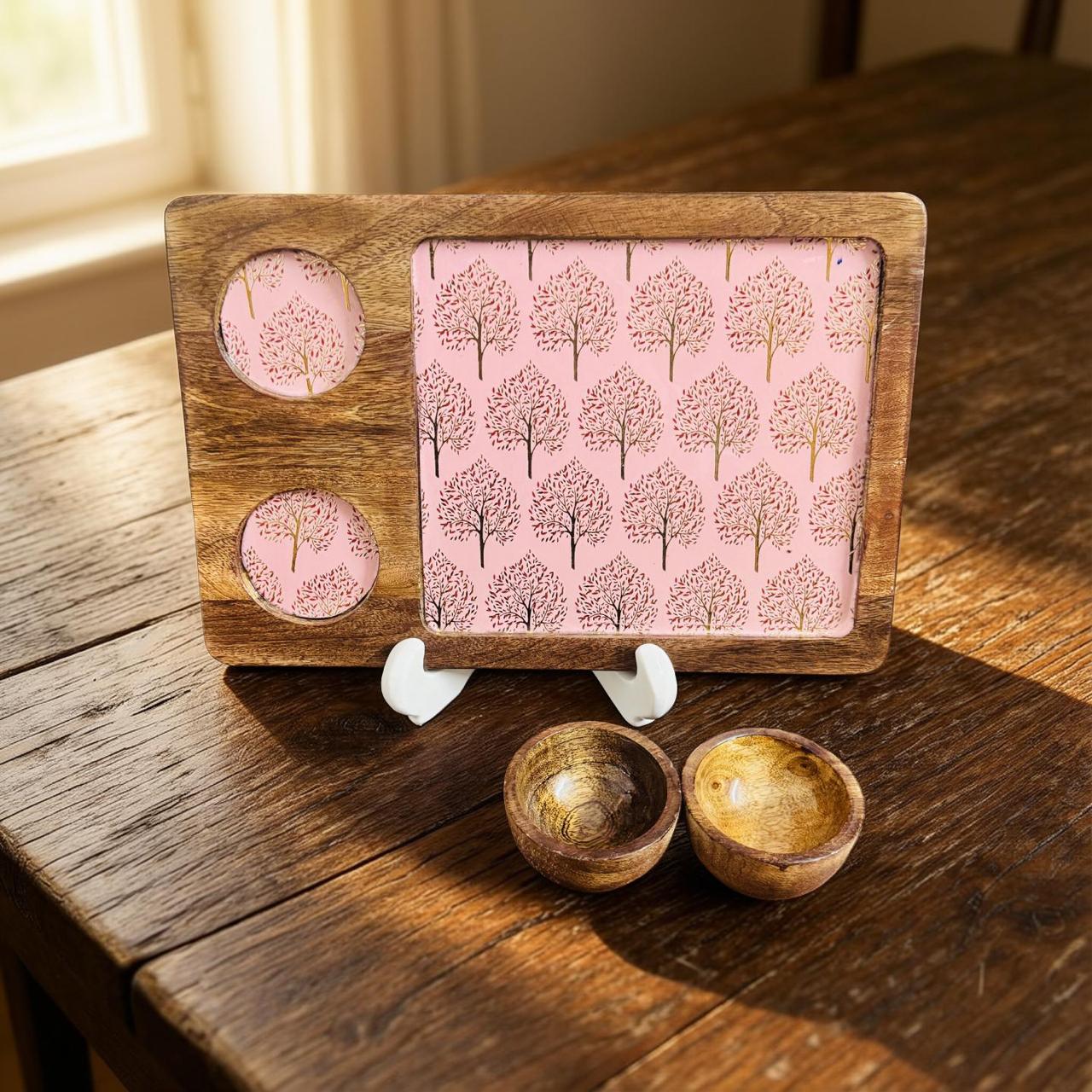 Wooden serving tray with pink tree design on a wooden surface