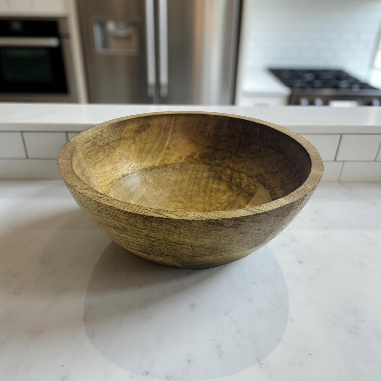 Wooden bowl on a marble countertop with a kitchen background