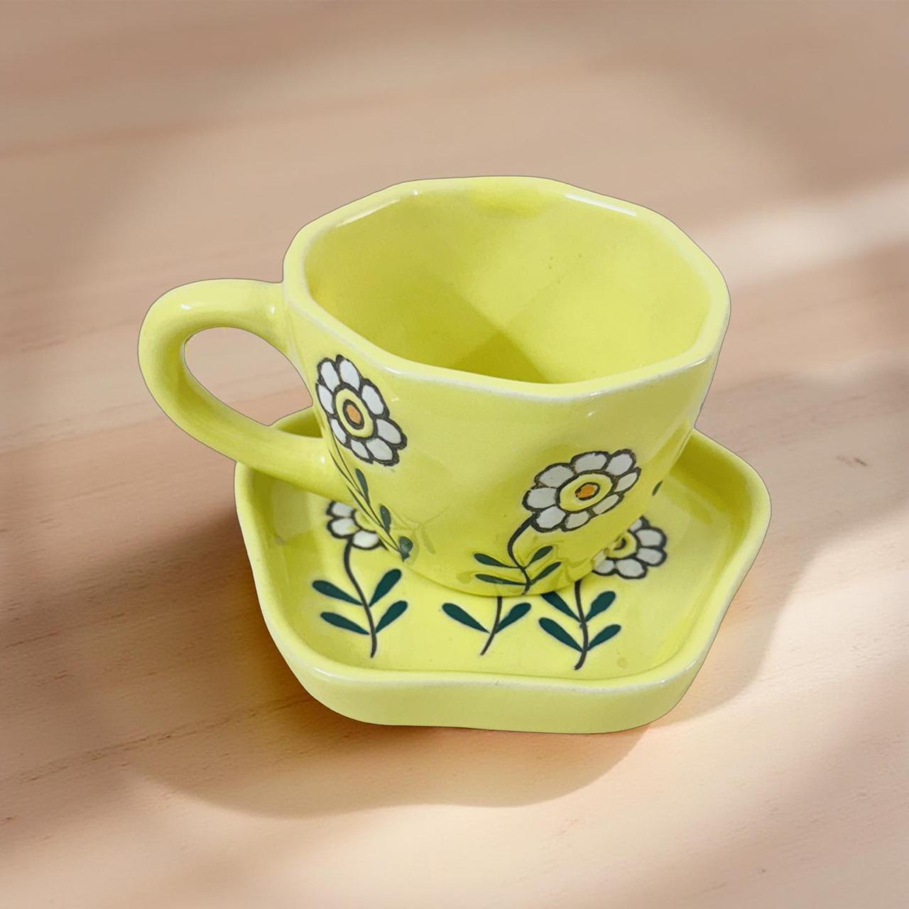 ceramic yellow mug with saucer set kepot on a woodenb surface